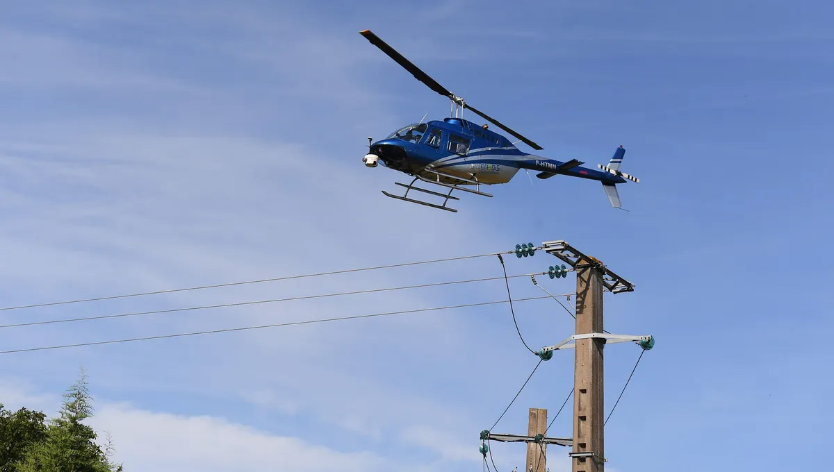 Hélicoptère survolant lignes électriques